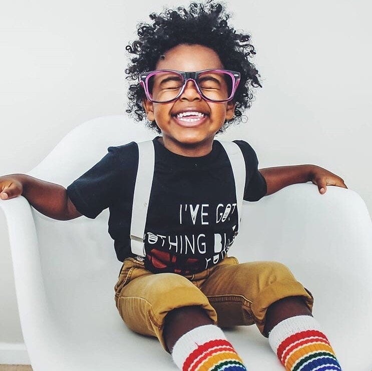 little boy smiling big in a chair