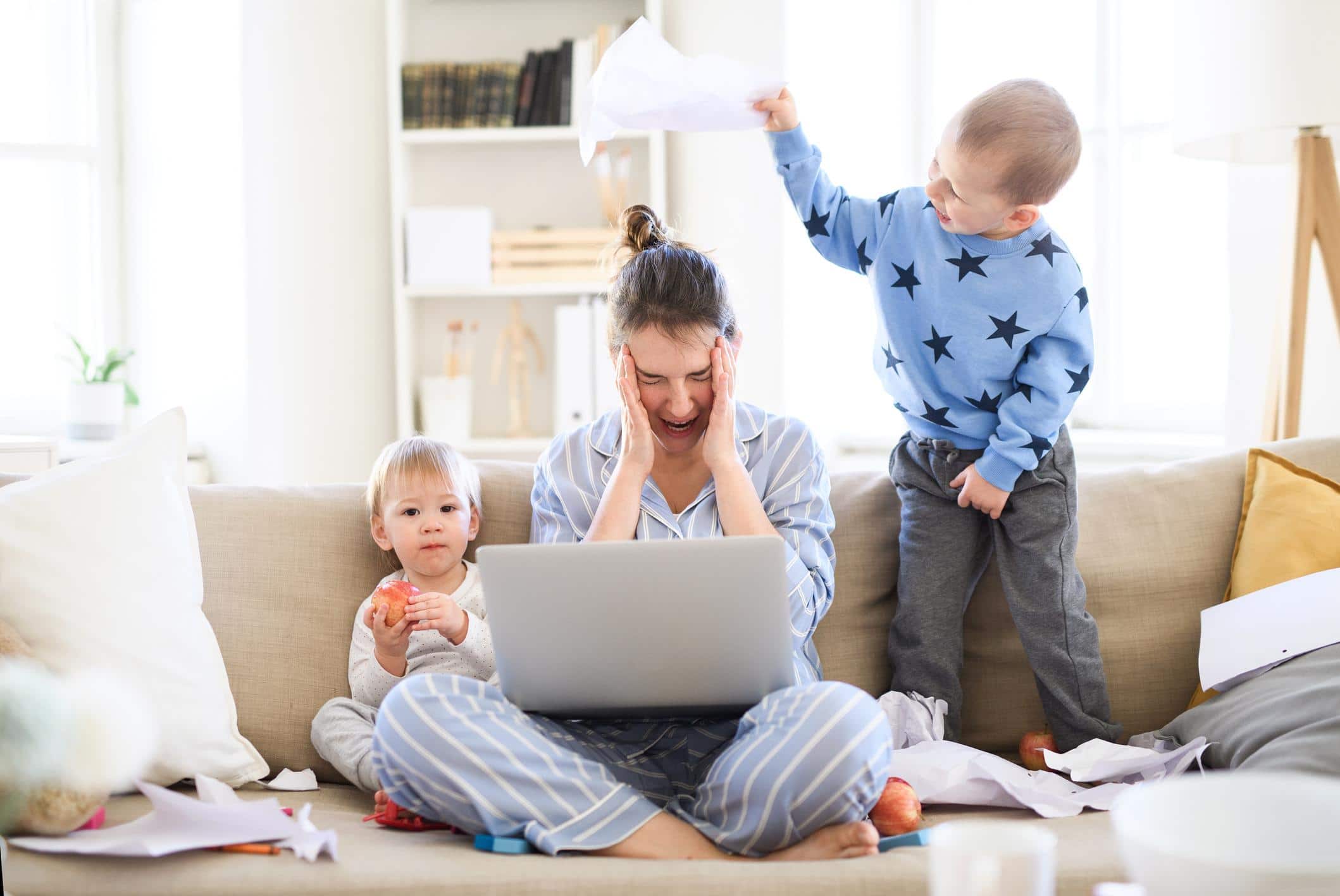 stressed out mom working between a toddler and a baby - burned-out working mom