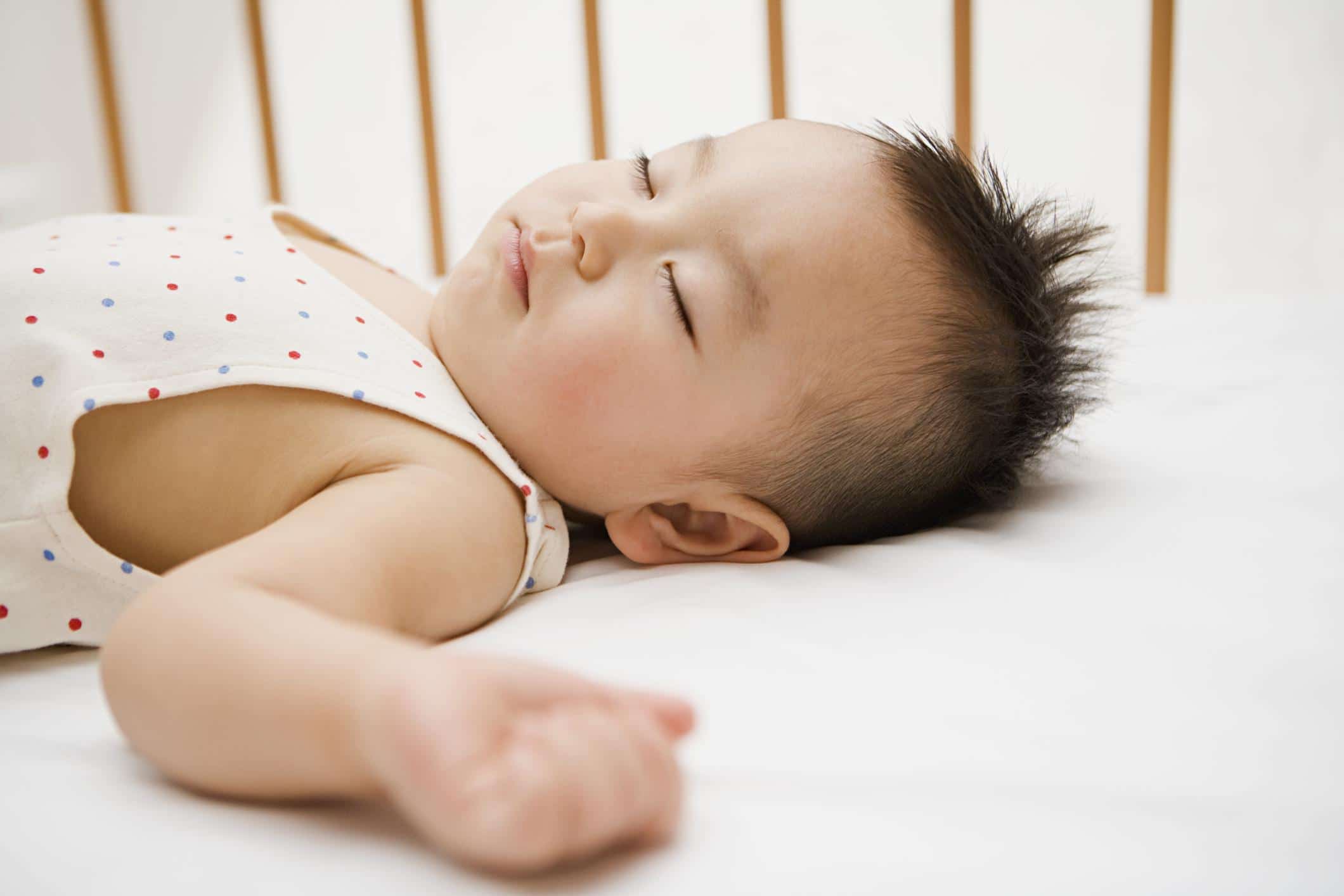 11-month-old baby sleeping on its back in a crib