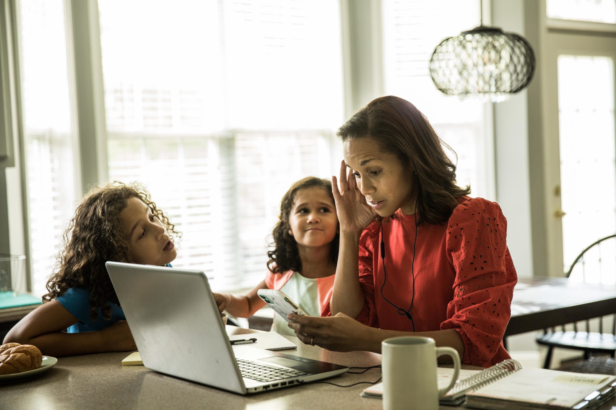 a woman and children looking at a laptop