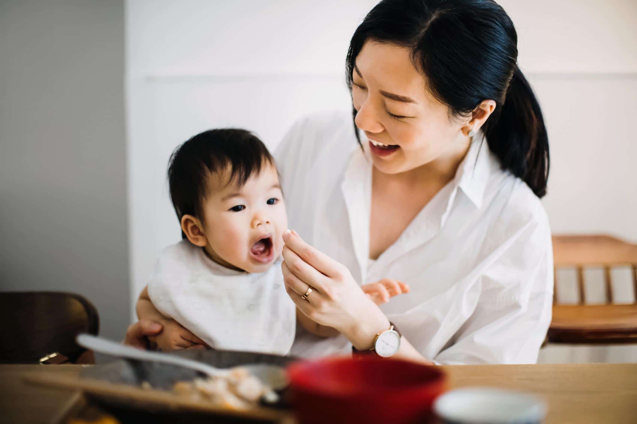 foods to build baby's brain: mom feeding baby solid foods