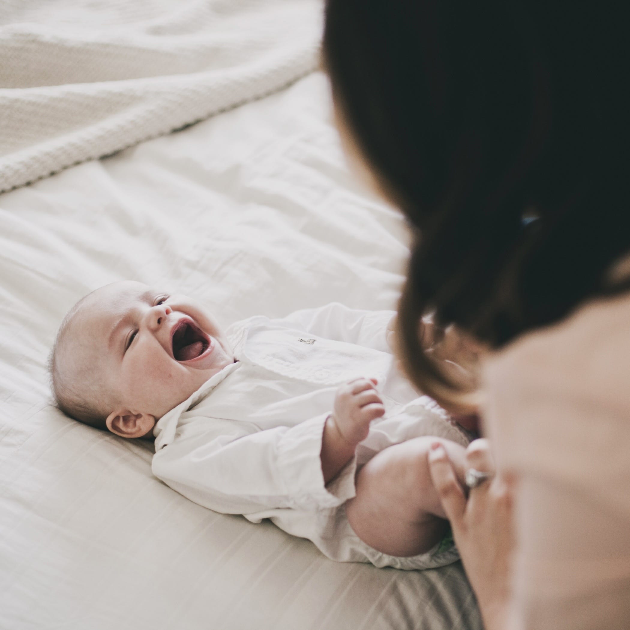 mom playing with smiling baby - activities for 6-month-old