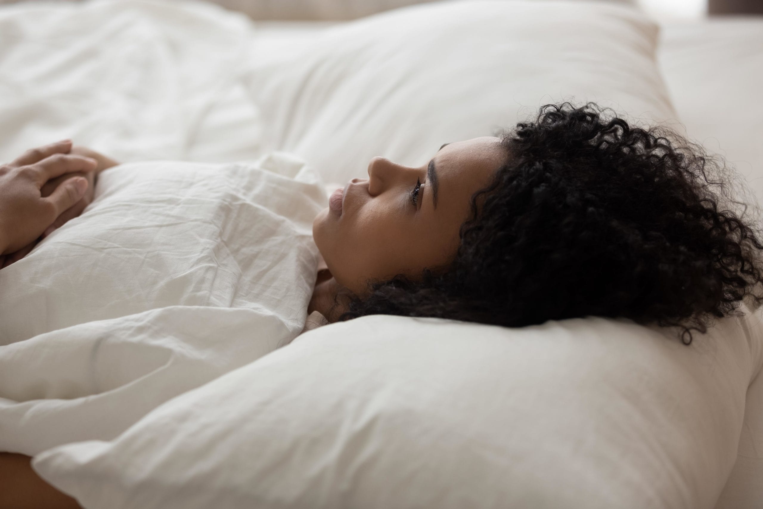 woman lying on bed staring at the ceiling and wondering what to say when a friend has a miscarriage