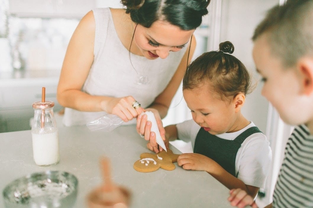 mom and daughter decorating christmas cookies together- the spirit of christmas