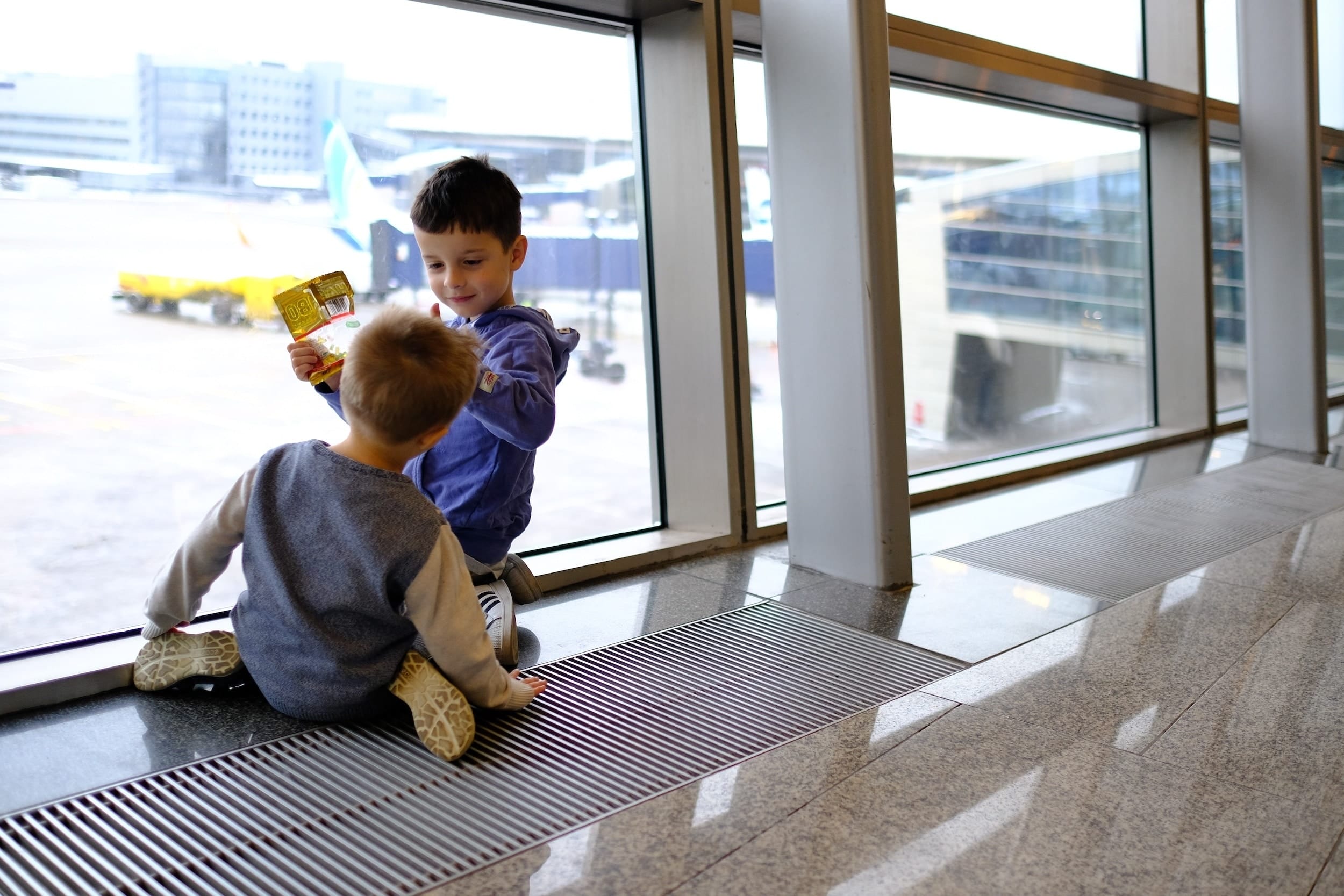 two kids playing at an airport