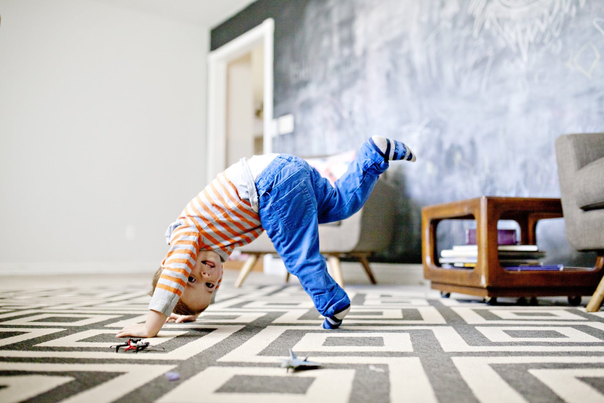 little boy playing on a rug inside