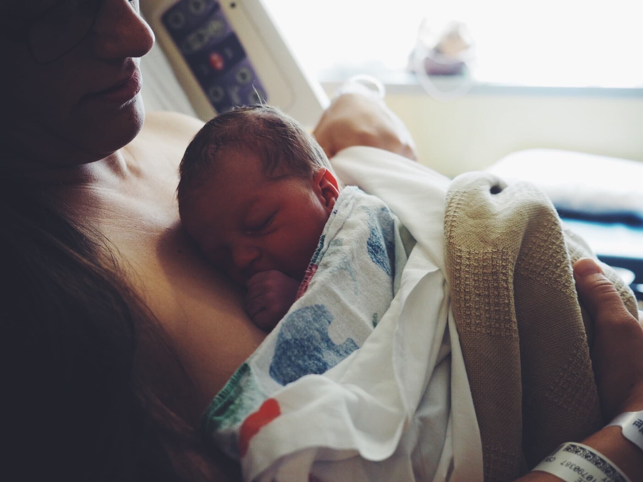 mom holding baby in a hospital bed