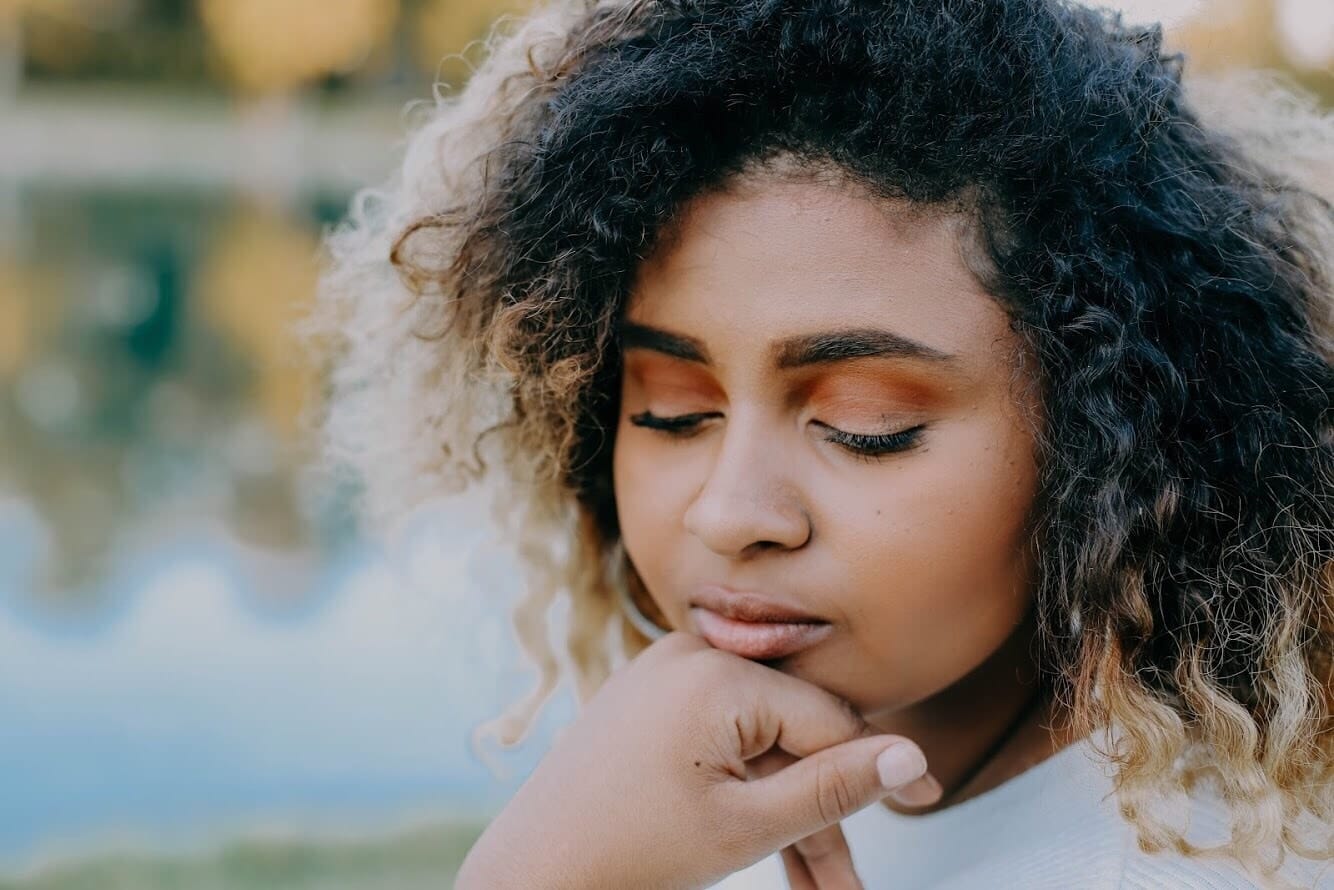 woman resting her head on her hand - black maternal mental health