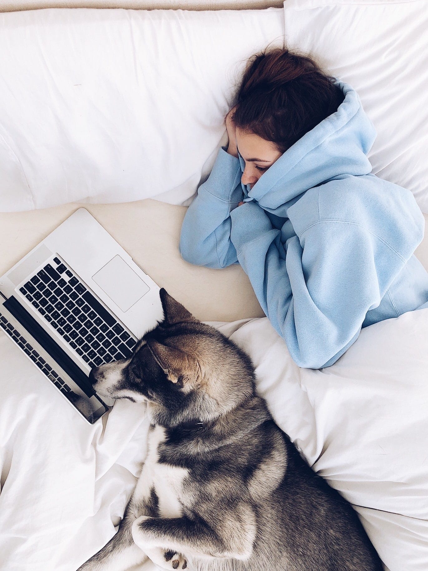 woman watching a movie on a laptop in bed