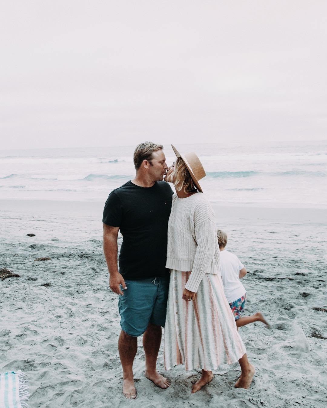 husband and wife kissing on the beach - how to stay in love with your spouse