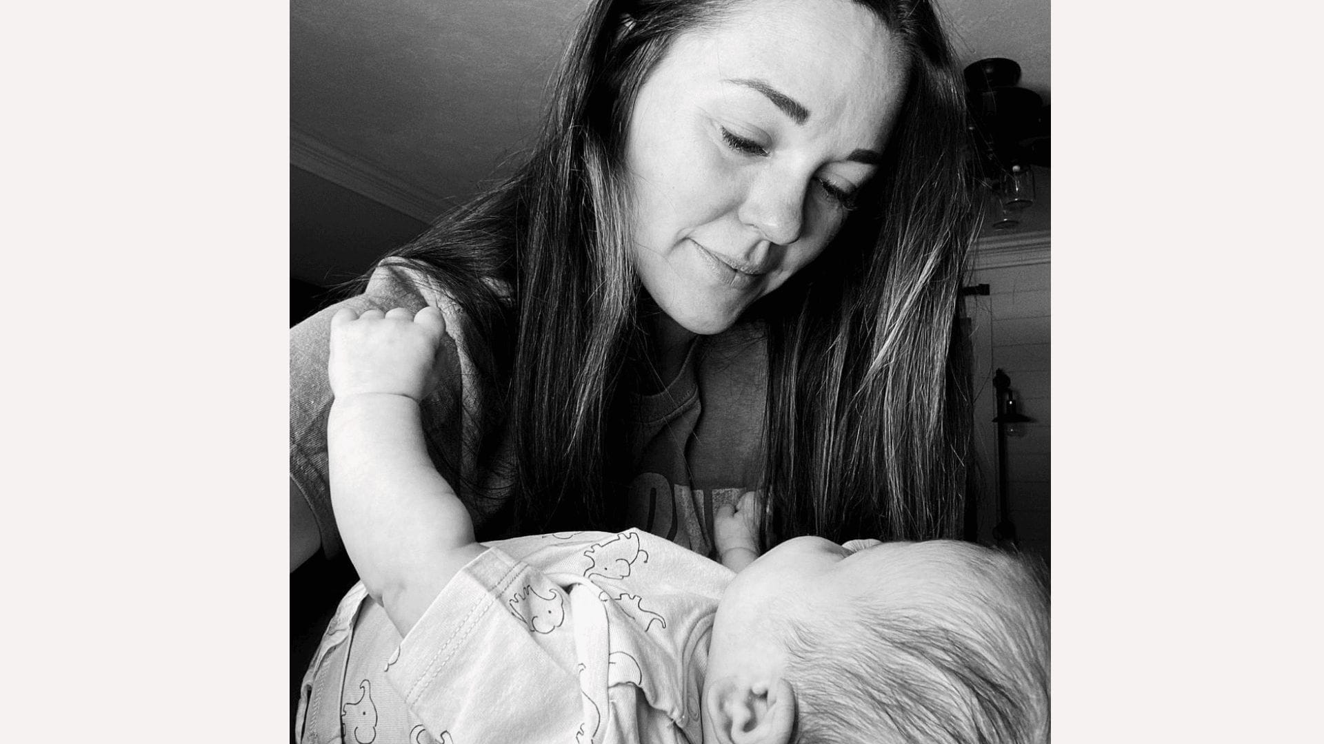 black and white photo of mom looking at baby