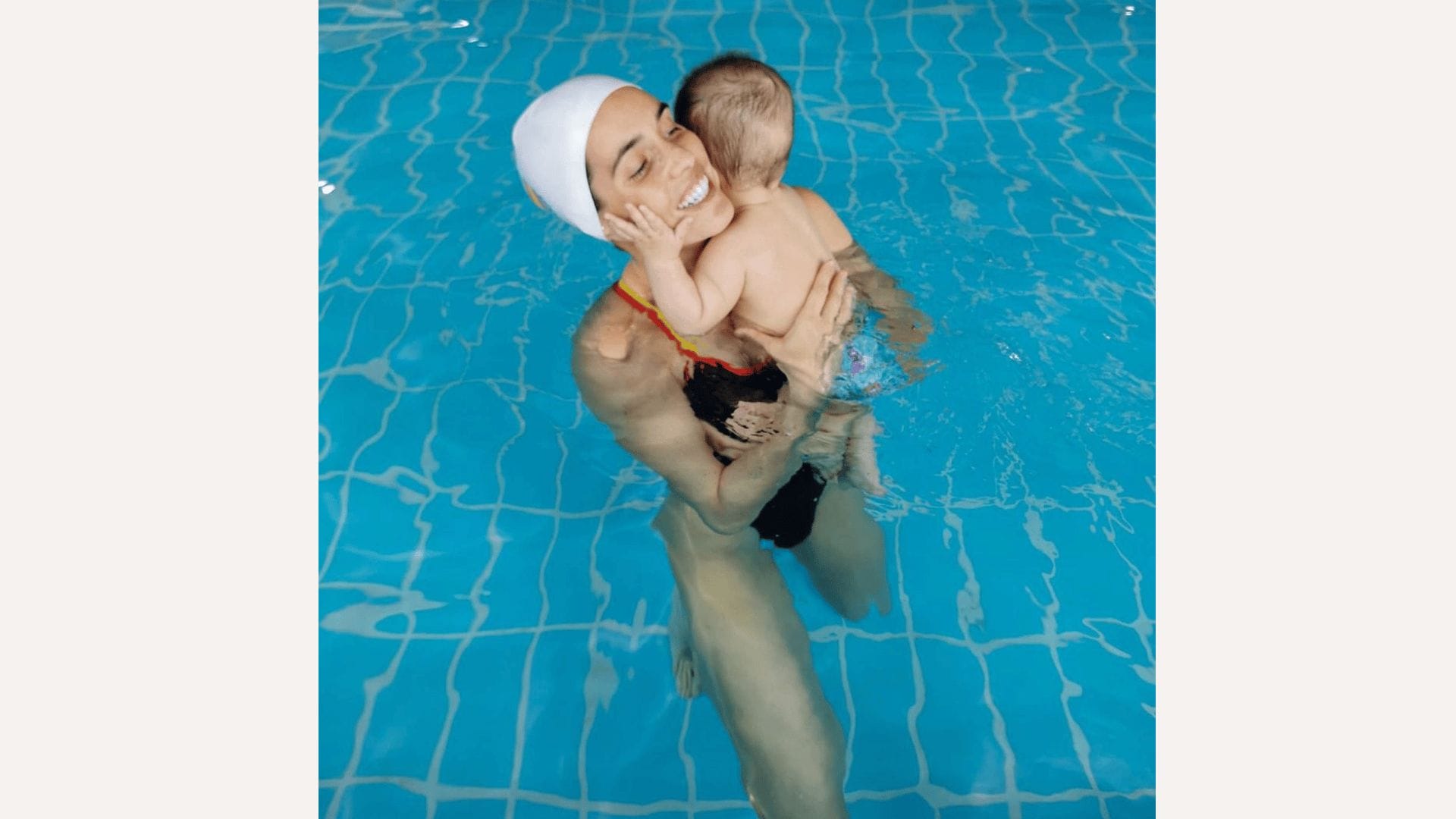 Olympic swimmer holding son in the pool