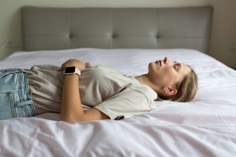 woman relaxing and resting on bed with eyes closed mental health