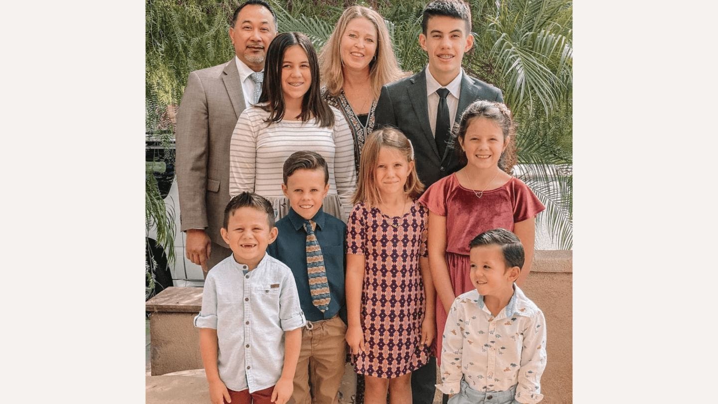 parents pose with their 7 adopted siblings