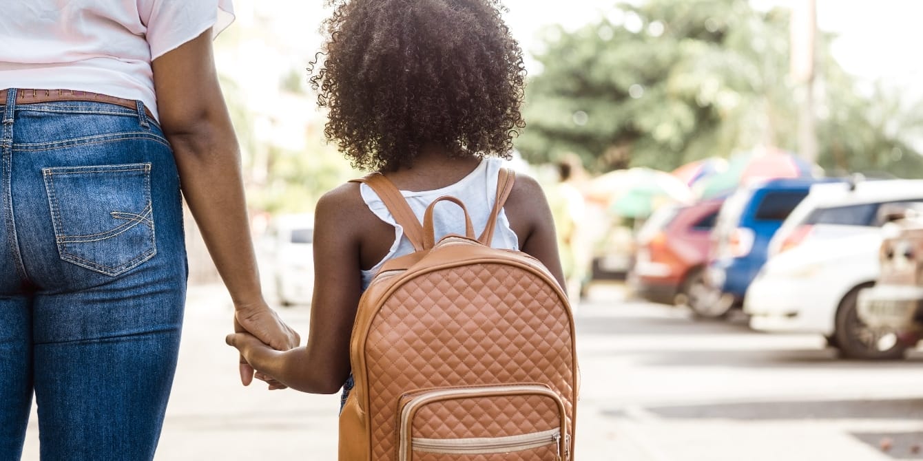 girl-wearing-kids-backpack-holding-moms-hand