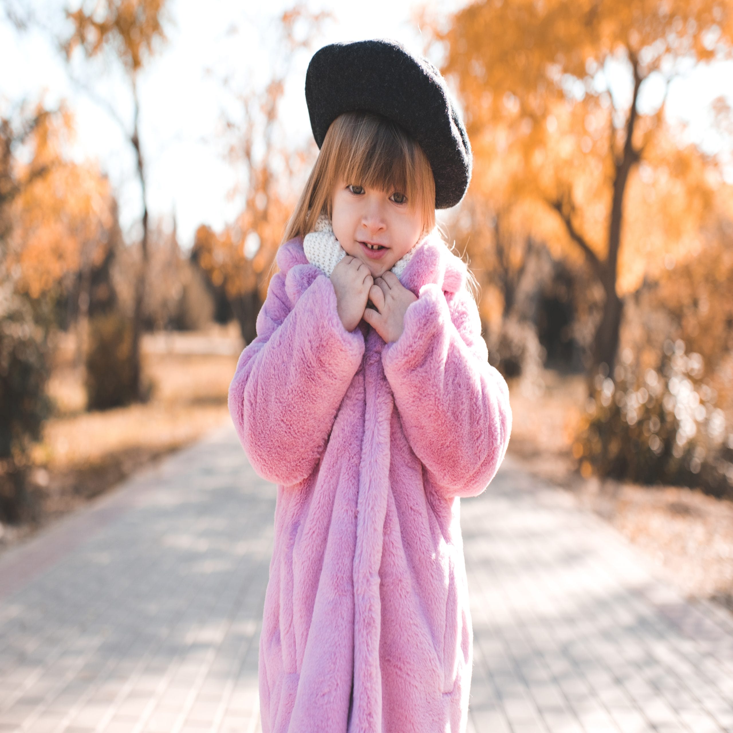 cute little girl wearing a french hat and a pink coat