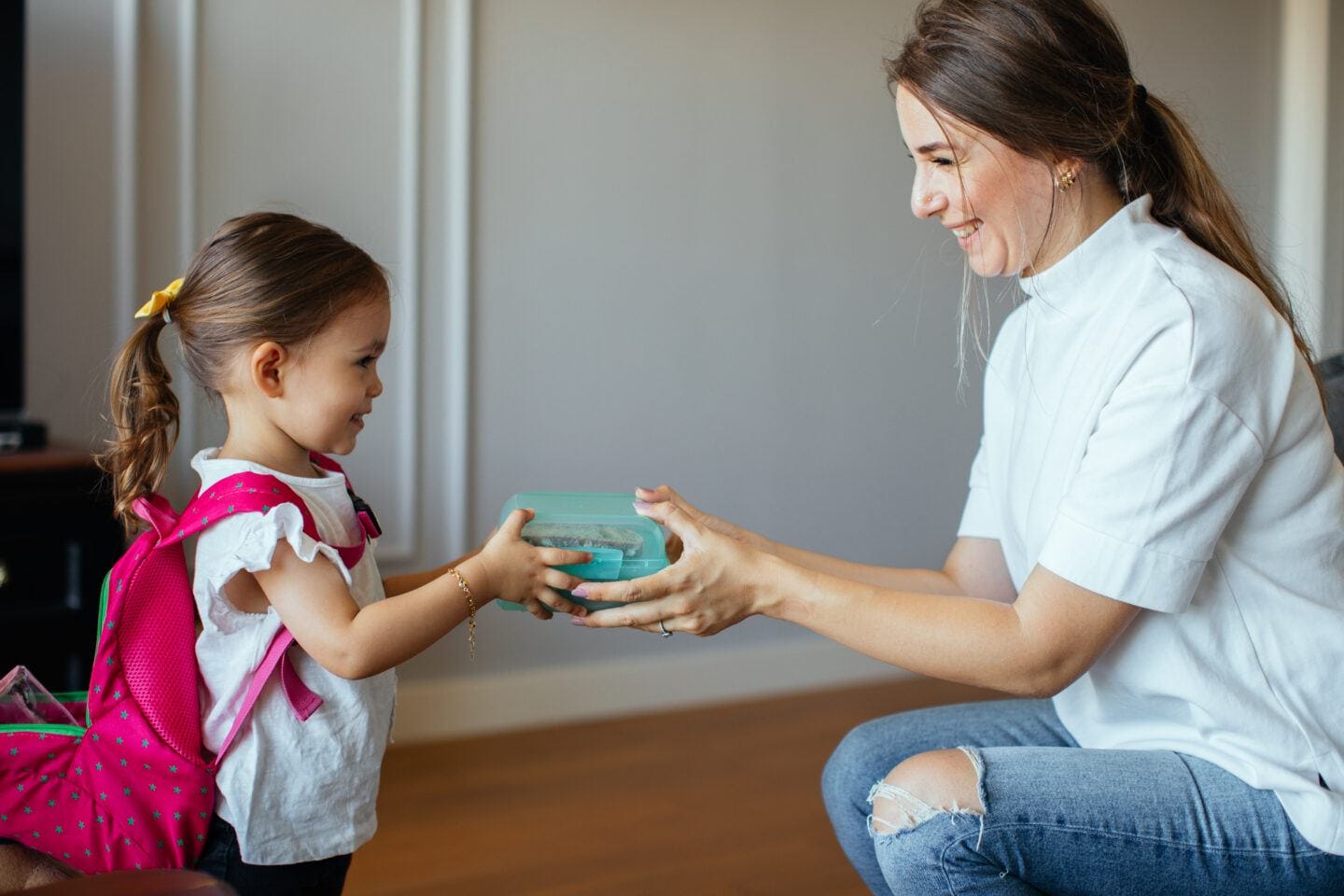 Mum putting lunch box with healthy food in backpack- lunch ideas for kids