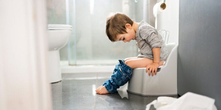 little boy sitting on a potty training toilet - potty training supplies