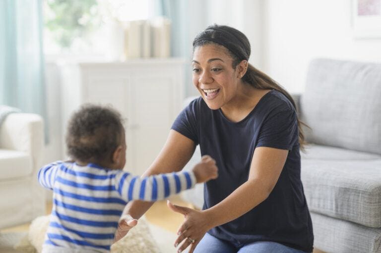 baby running into the arms of its mother, who has just learned about the new aap developmental milestones