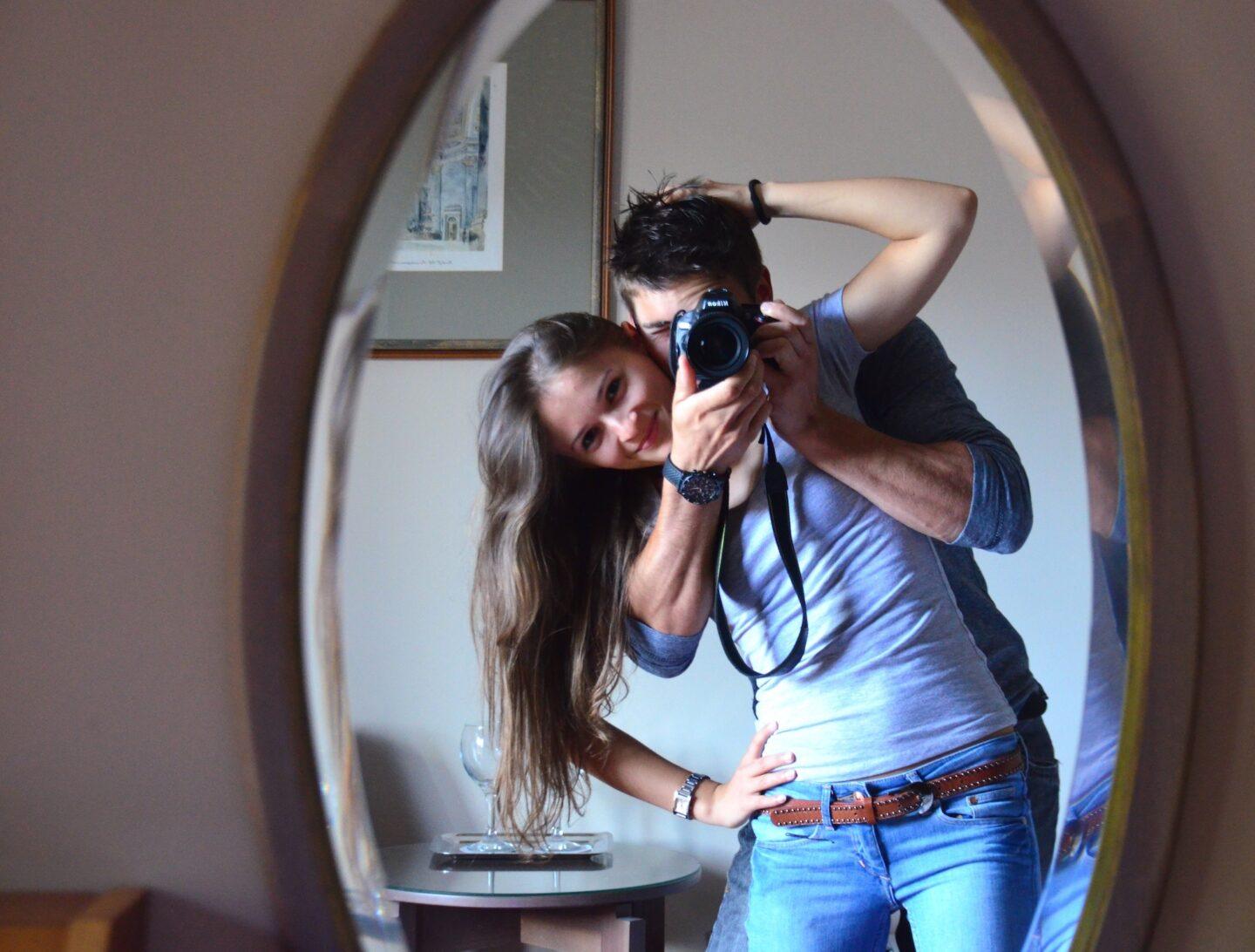 couple taking a mirror selfie with a digital camera