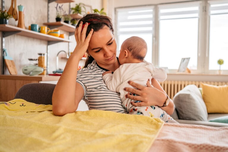 why is my libido so low: mother holding infant looking tired