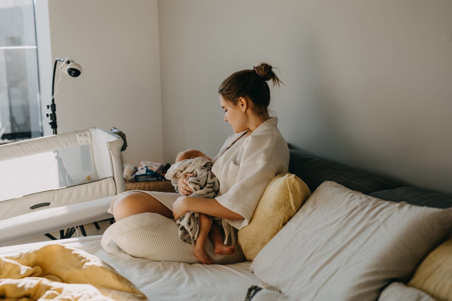 Mother and baby sitting in bed