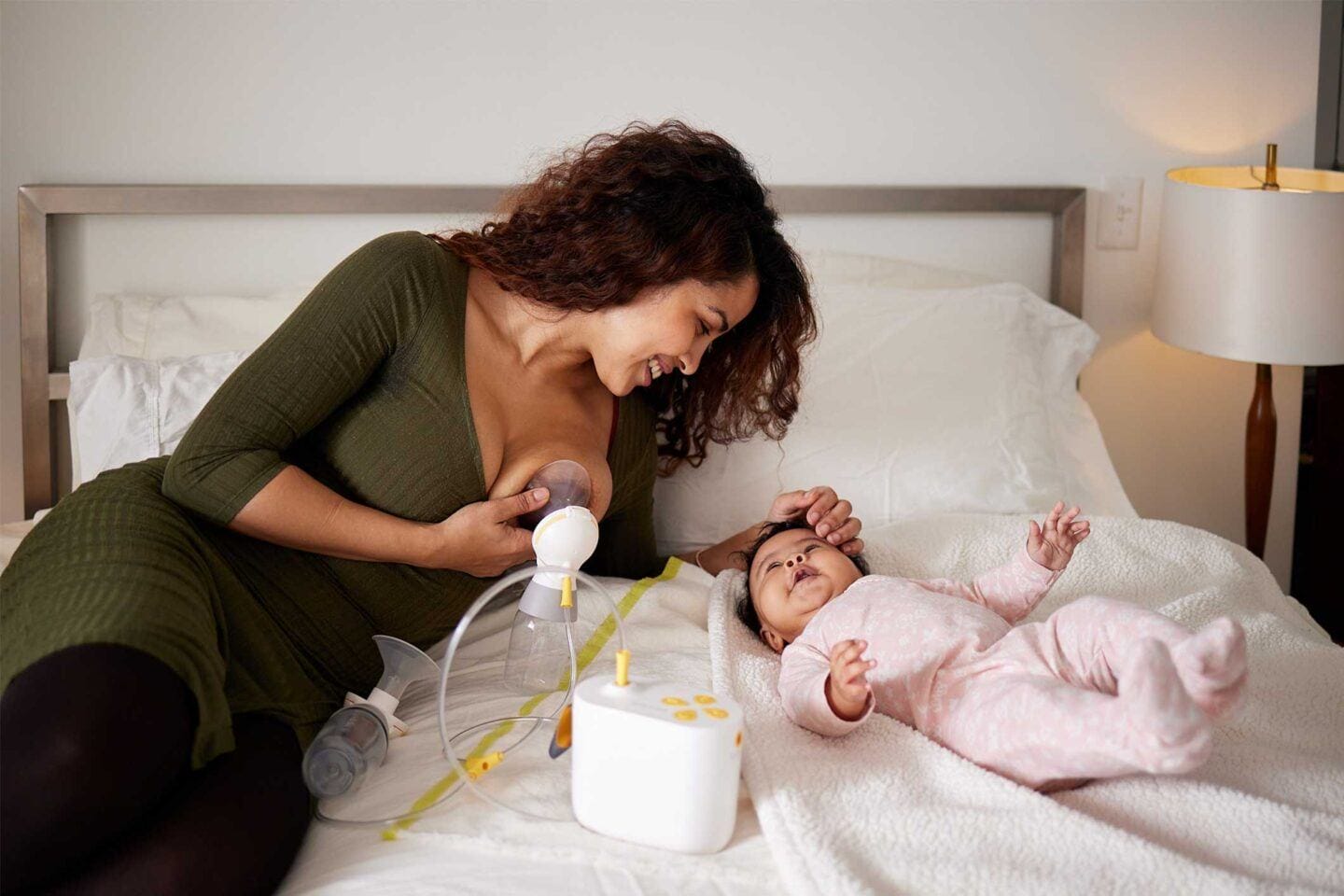 mom using breastpump in bed Motherly