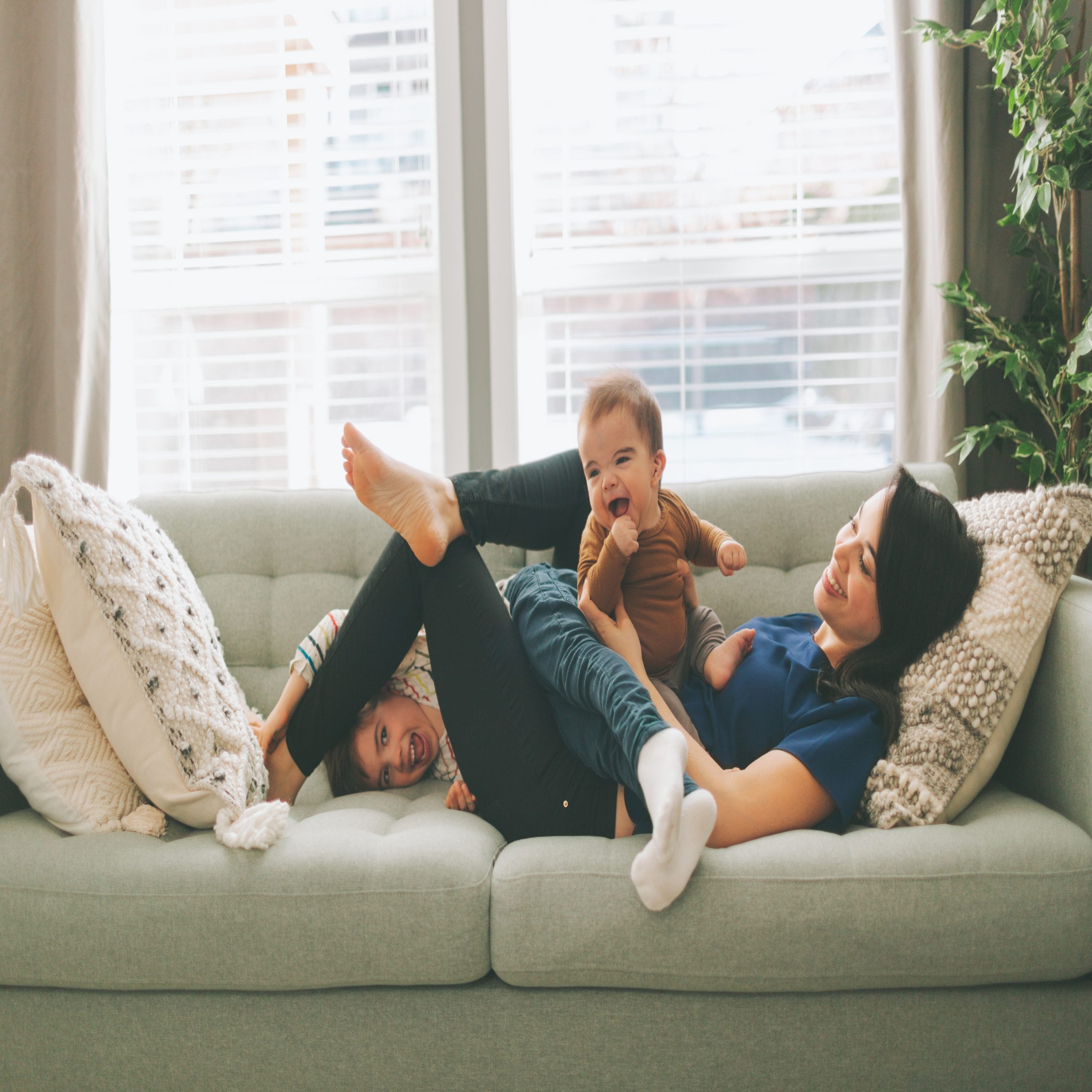 mother and sons laughing on the couch