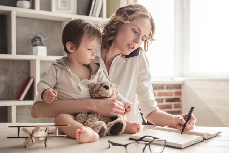 childcare: state of motherhood mother holding baby while talking on phone and working at home