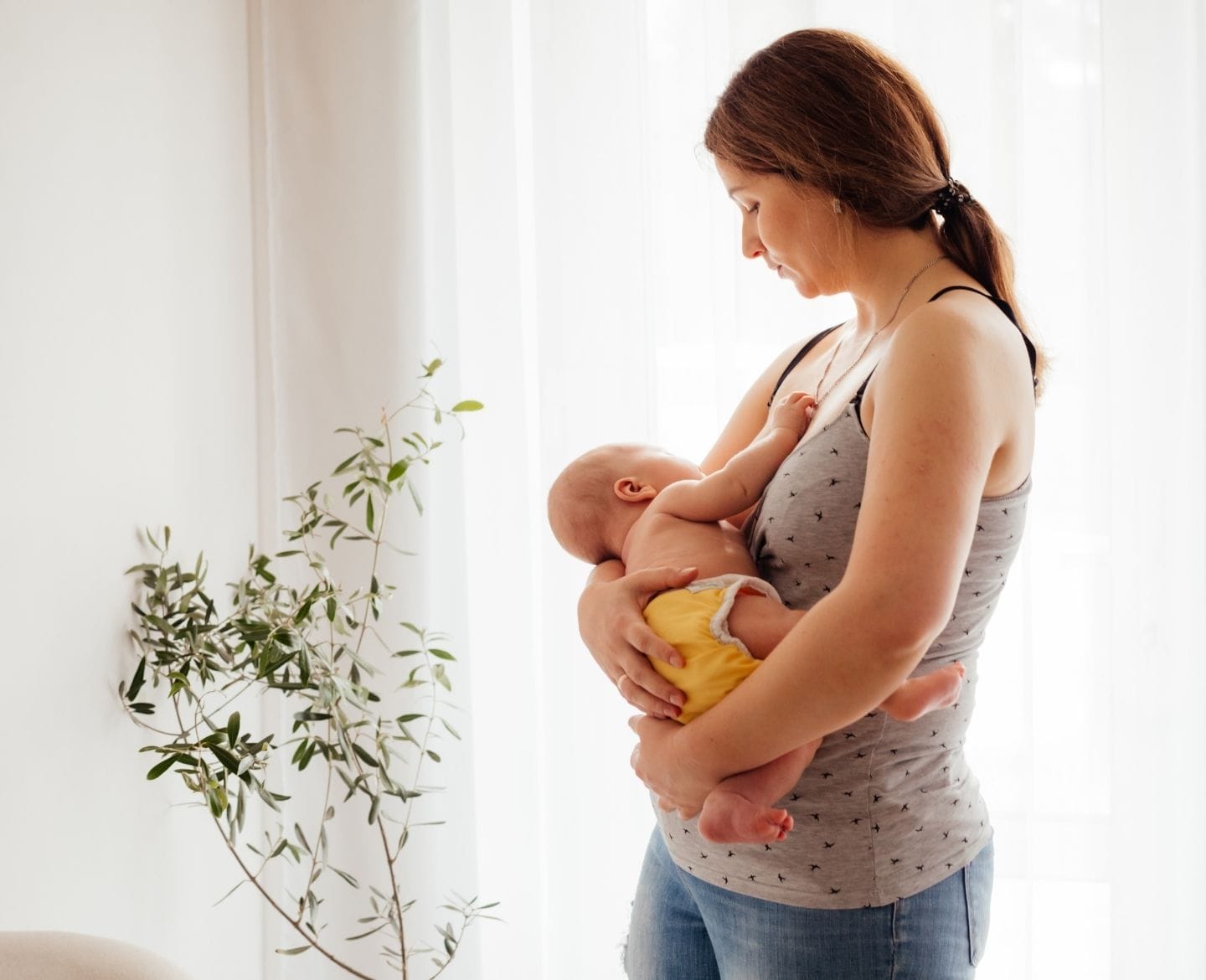 postpartum body image: woman holding baby