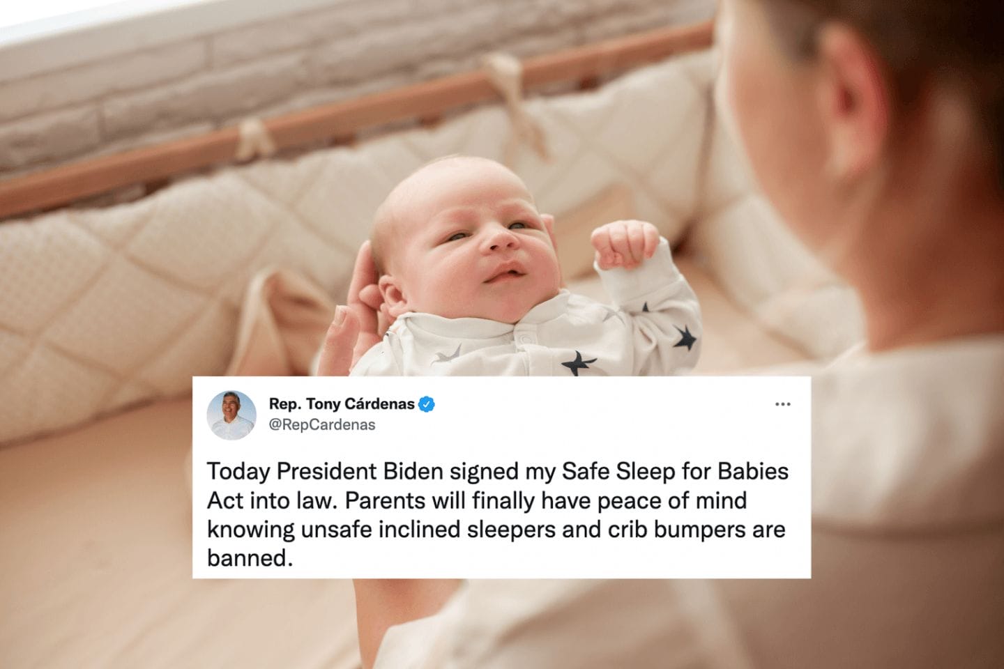 safe sleep: mom holding baby above crib with crib bumper