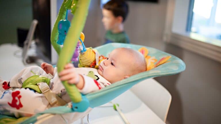 Baby sitting in a Fisher Price rocker