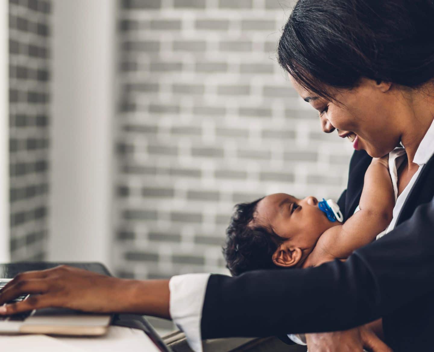 working mom at computer with baby