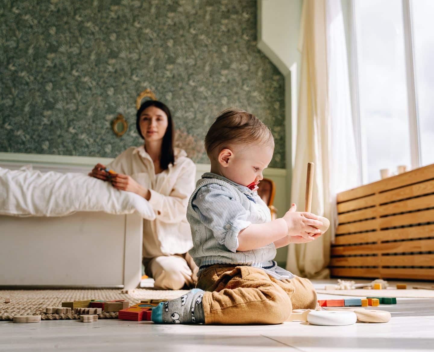 child playing with toys while mom watches