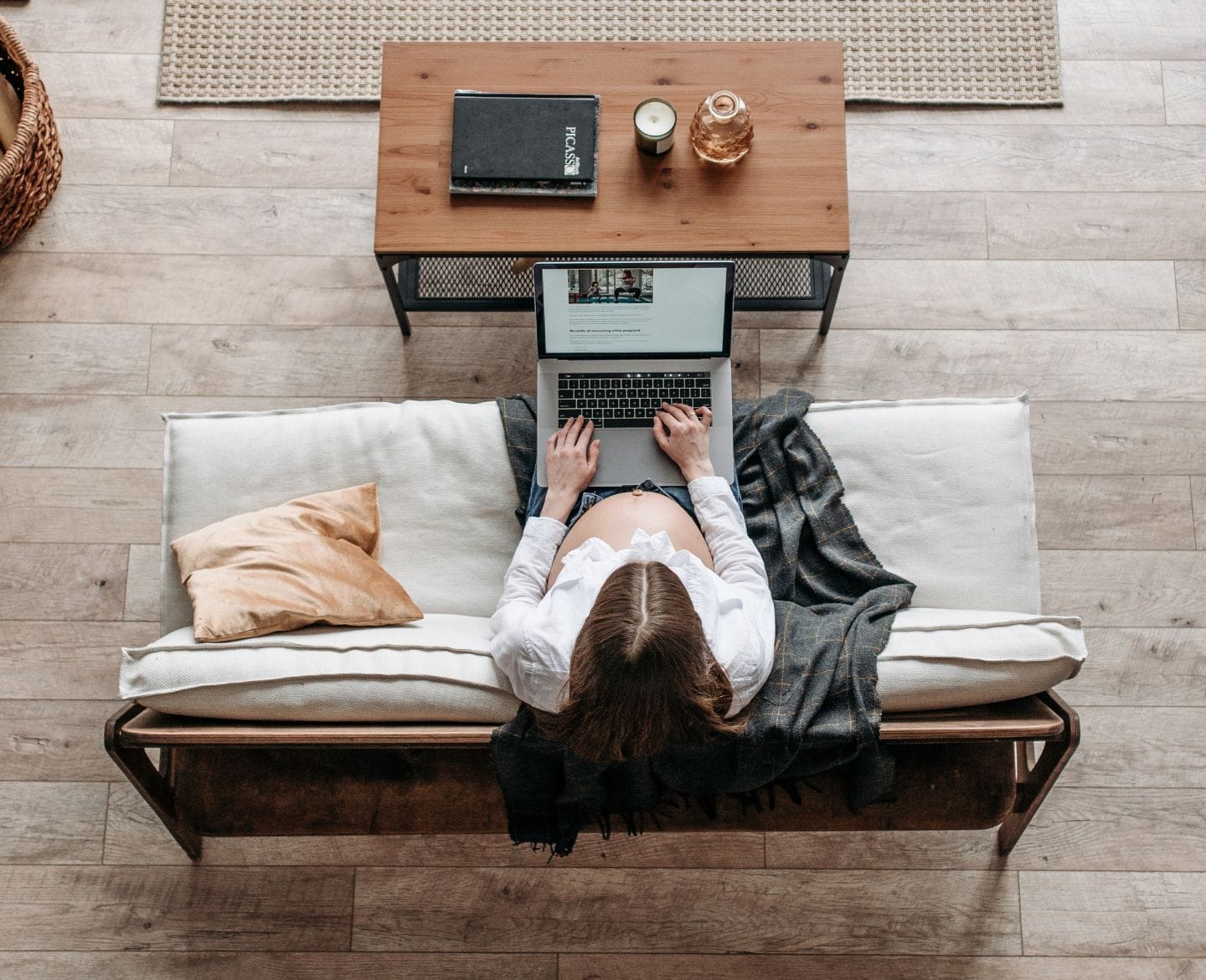 aerial shot of pregnant woman working on a laptop