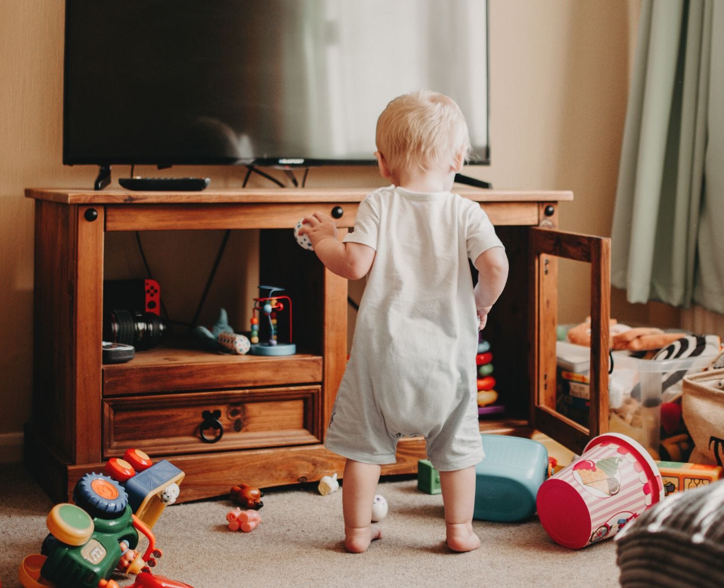 kid playing with toys all over floor