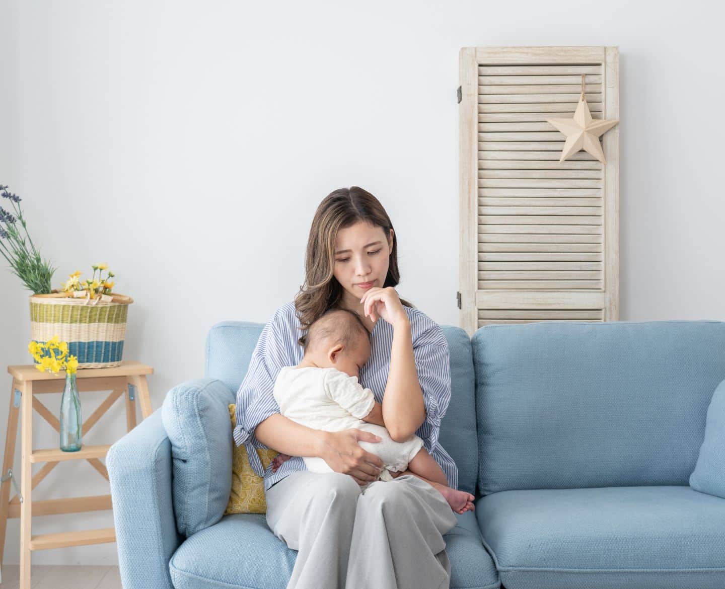 woman sitting on couch holding baby