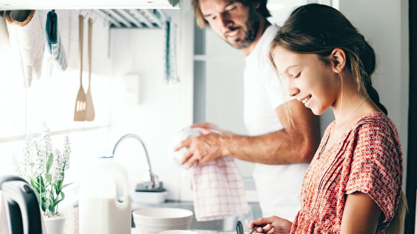 Dad and daughter in kitchen - bivalent boosters for kids