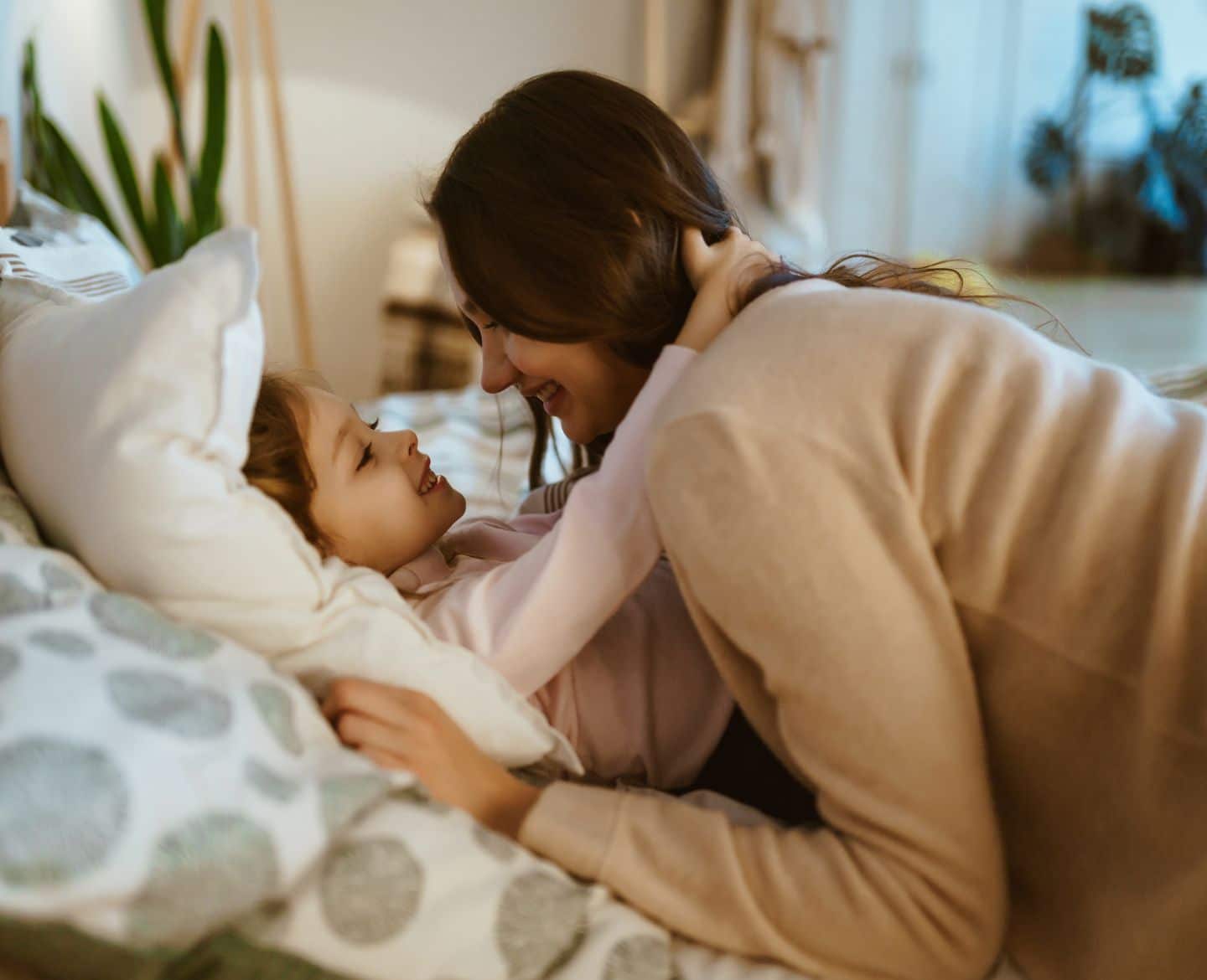 daughter laying in bed hugging mom - perfect parents