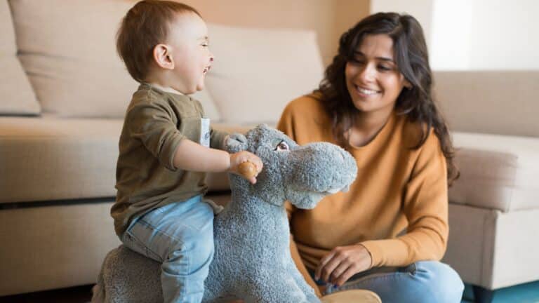 mom watching child play on rocking horse - sahm