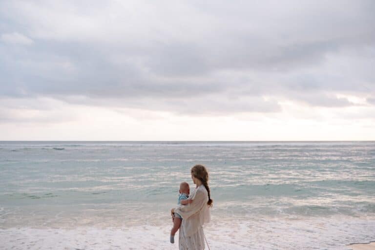 mother holding baby at the beach - motherhood and trauma