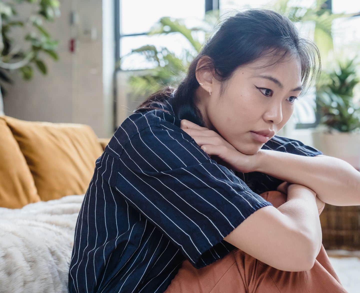 woman sitting on bed thinking - anxiety spiral