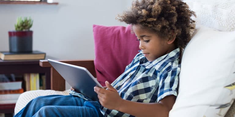 young boy playing on tablet - limiting screen time for kids