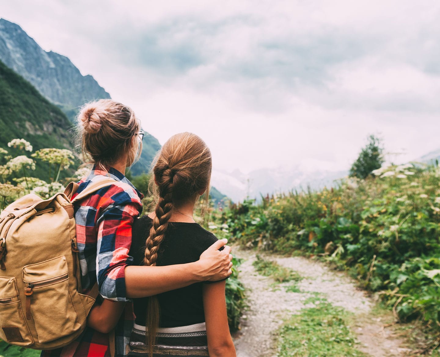 mom with her arm around her daughter on a hike - mother daughter trips