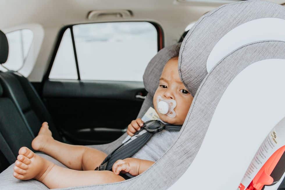 baby sitting in rear-facing car seat. transition from car seat to booster - Motherly