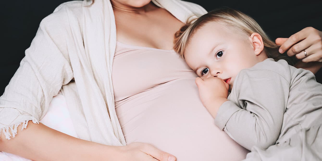 to my firstborn, pregnant mom sitting with child laying on her belly