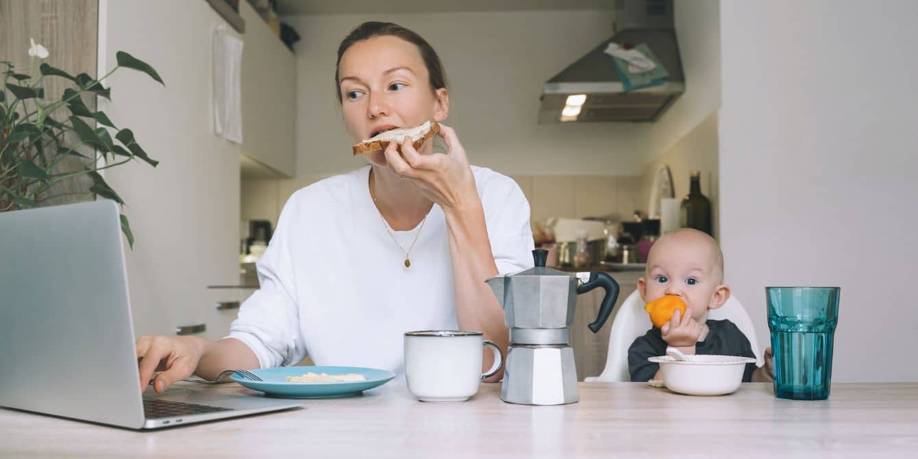 mom eating toast while working and baby eating next to her- easy meals for busy moms