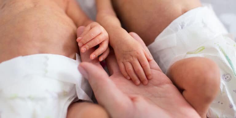 mom holding micropreemie twins' hands