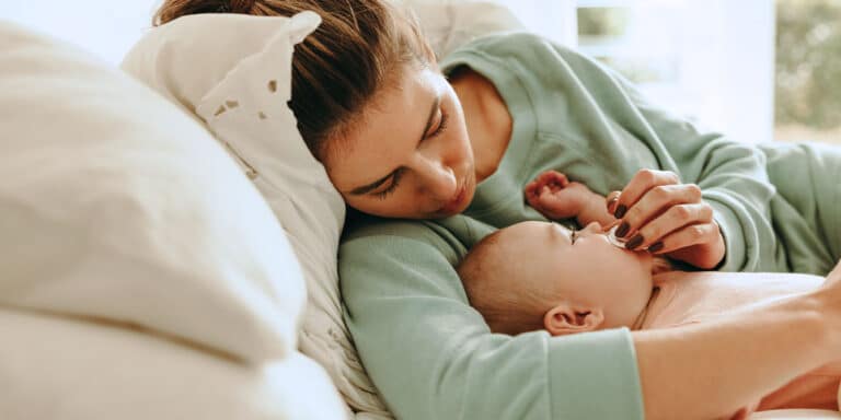 mom laying down with her newborn Motherly