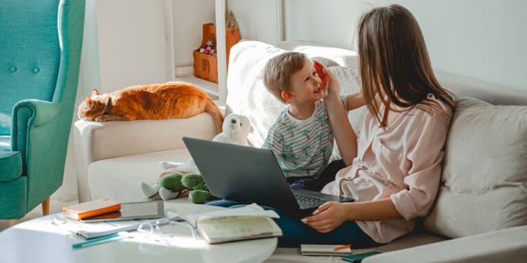 multitasking mom working and playing with her son